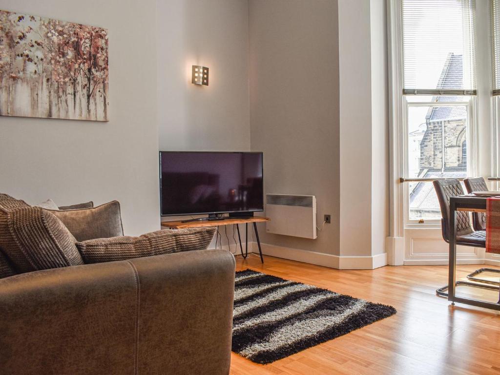 a living room with a couch and a flat screen tv at Church View Apartment in Scarborough