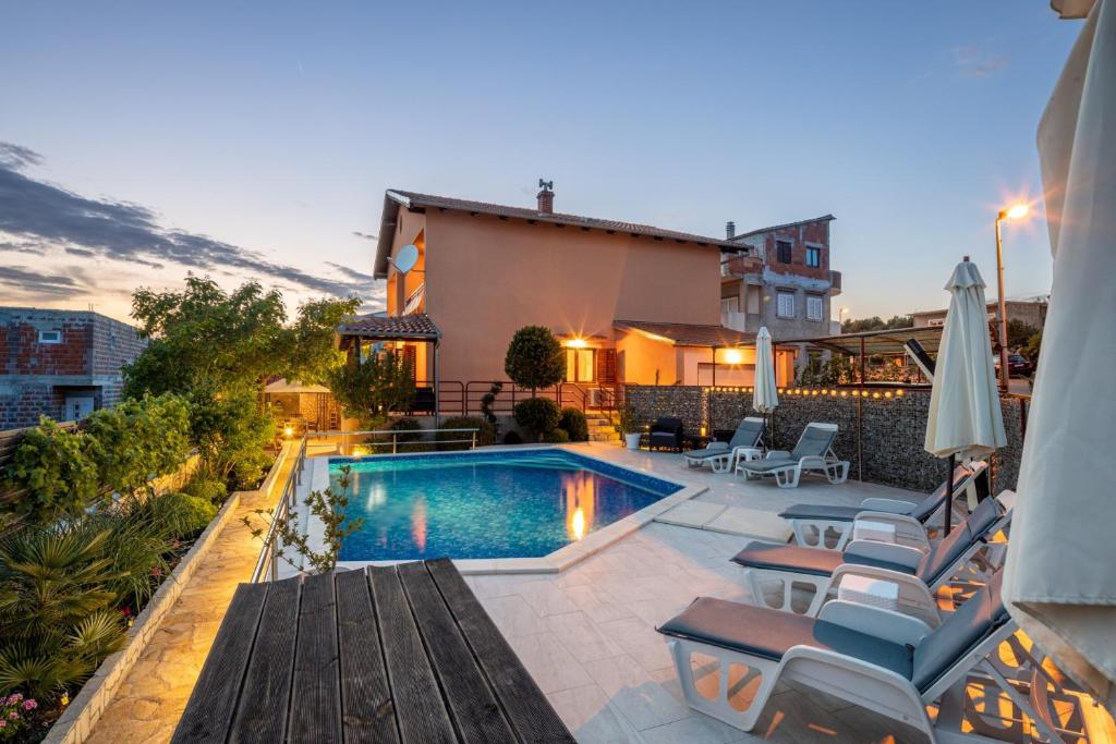 een achtertuin met een zwembad en een huis bij Villa Salvia Mare in Bilice
