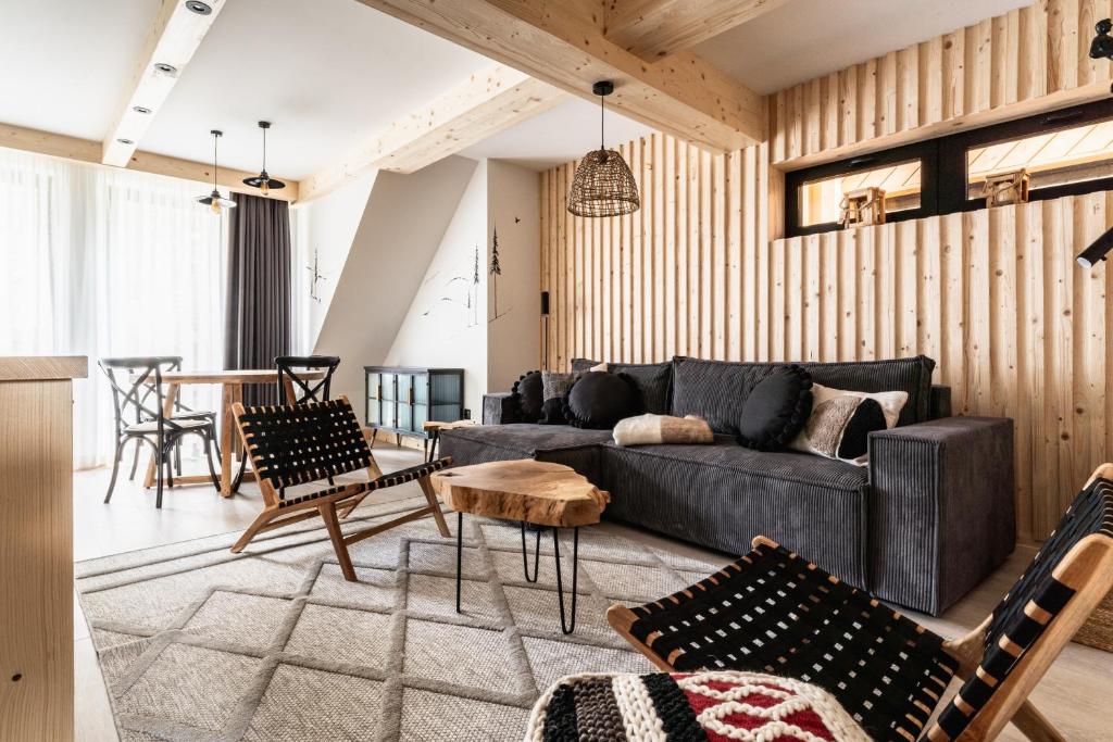 a living room with a couch and chairs and a table at ZAKOHOME- Apartamenty Sabały in Zakopane
