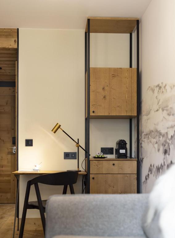 a living room with a desk and a lamp at HIGALIK HOTEL in Les Menuires