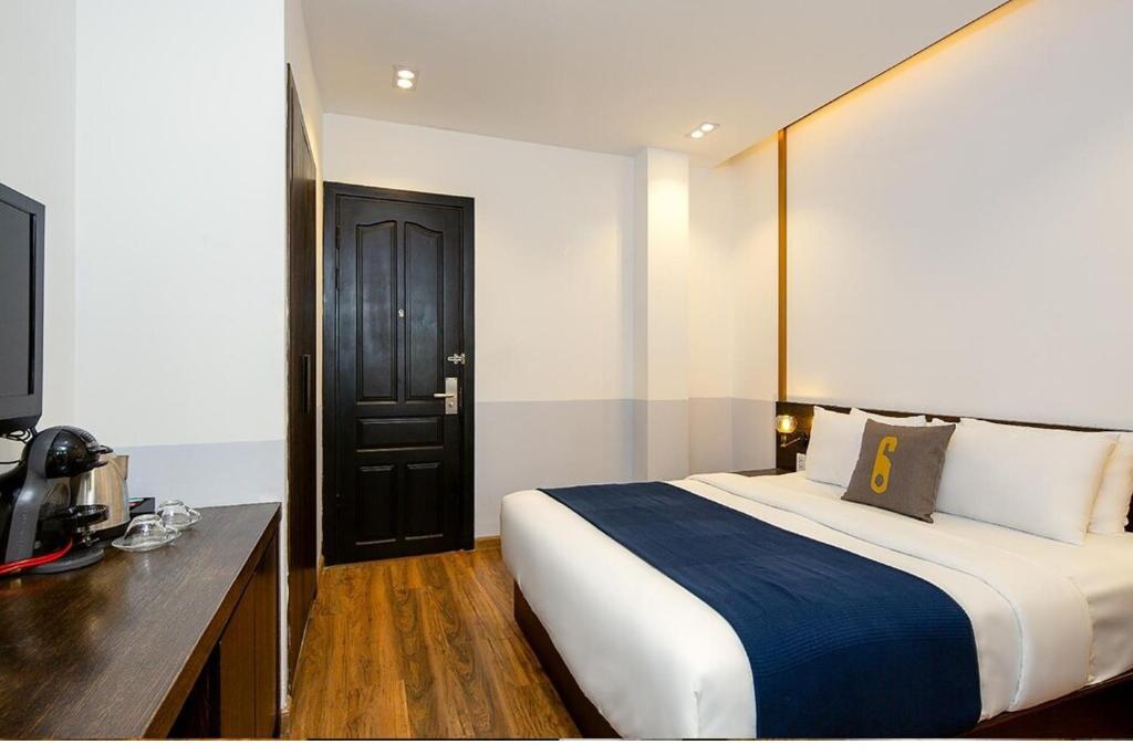 1 dormitorio con 1 cama grande y puerta negra en Sea Sand 2 - Hotel, en Da Nang