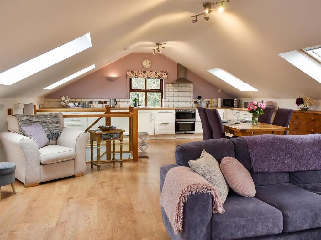 a living room with a couch and a kitchen at Owls Rest in Burley in Wharfedale