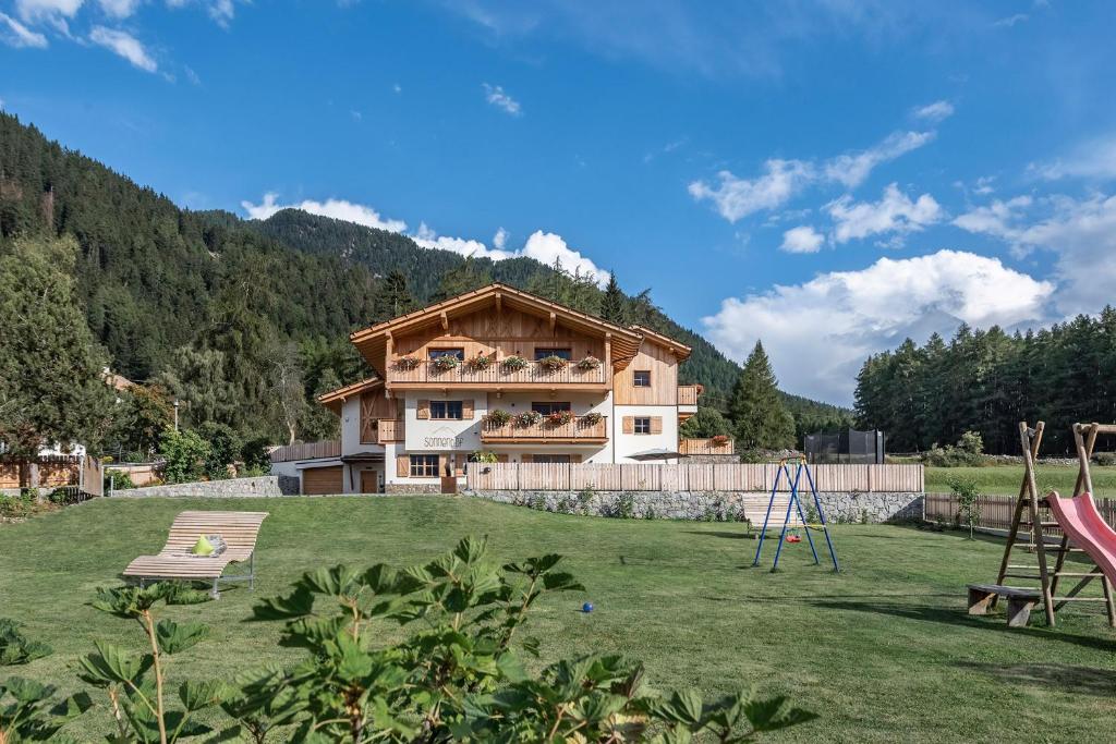 a house in a field with a playground at Mein Sonnenhof in San Valentino alla Muta