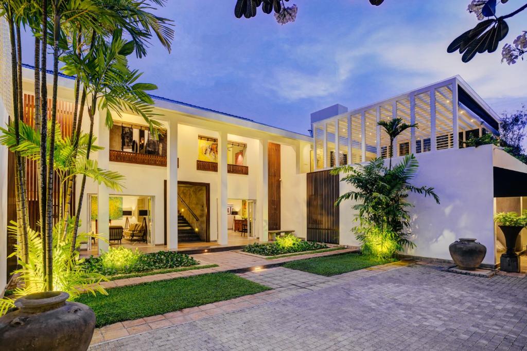 una vista exterior de una casa con palmeras en Nyne Hotels - Lake Lodge, Colombo, en Colombo