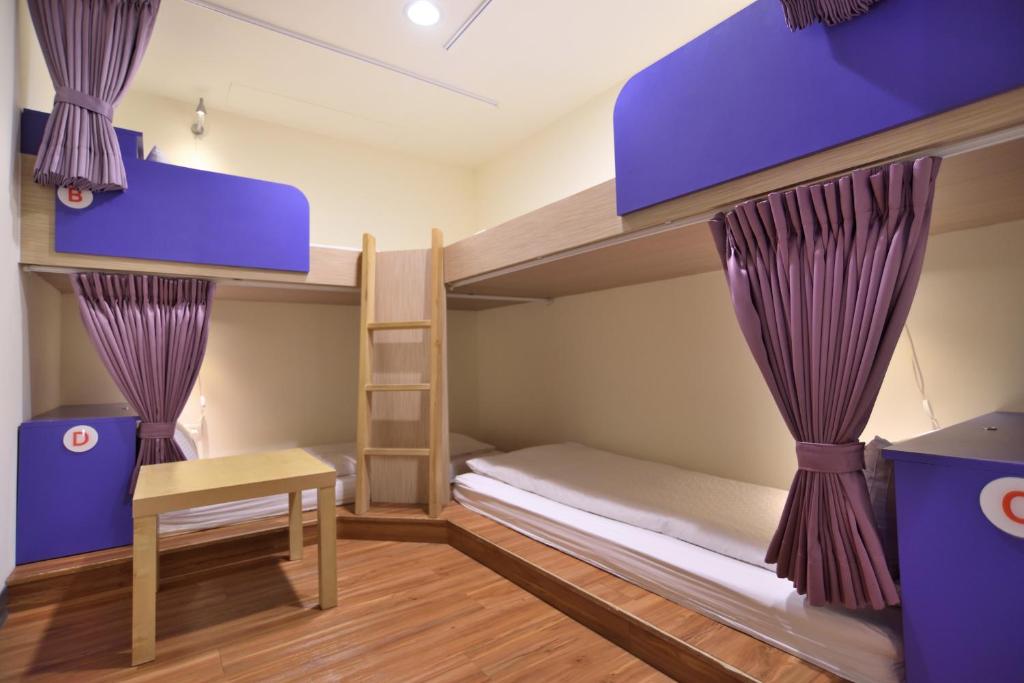 a bedroom with bunk beds with a desk and a ladder at CU Hotel Taipei in Taipei