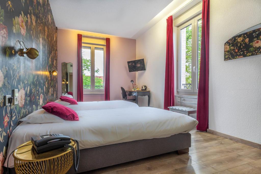 - une chambre avec un grand lit blanc et des oreillers roses dans l'établissement Hôtel d'Angleterre (by Popinns), à Vittel