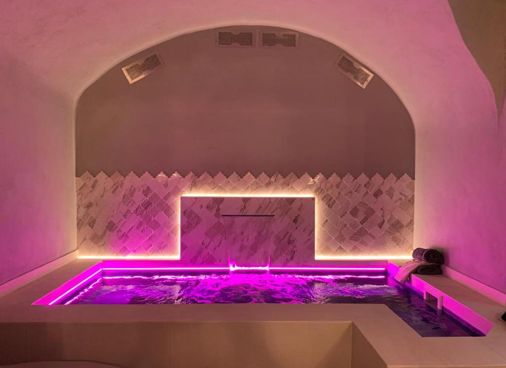 bañera rosa con iluminación púrpura en una habitación en La Pecora Nera en Rocchetta Nervina