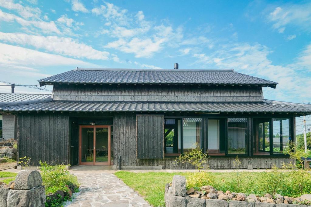 uma casa de madeira com um telhado preto em 菜を｜NAWO em Goto