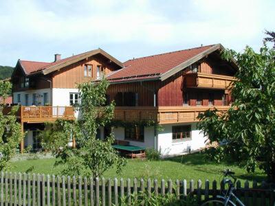 a large wooden house with a fence in front of it at Gästehaus Alpin - inkl. Chiemgau-Karte in Bergen
