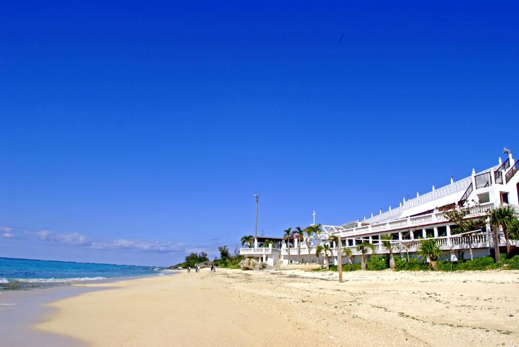 a view of a beach with a building and the ocean at Beach Resort Morimar in Yomitan