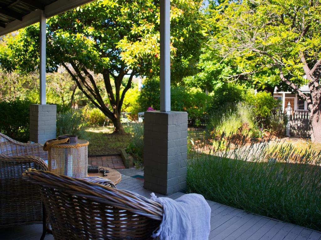 un patio con mesa y sillas en un porche en Spa Villas on Main, en Hepburn Springs
