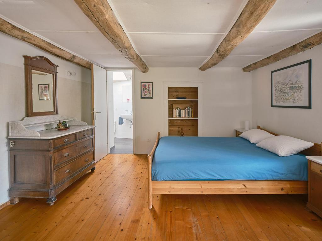 Osteria Grütli con alloggio في Borgnone: غرفة نوم بسرير ازرق وخزانة