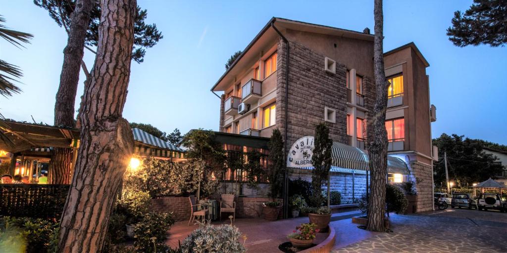 un bâtiment avec des arbres devant lui dans l'établissement Hotel Il Cavaliere Nero, à Tirrenia