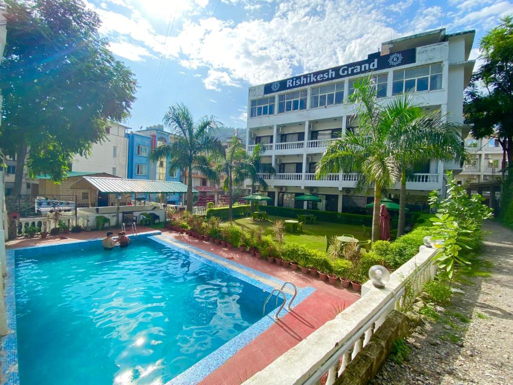 a large swimming pool in front of a building at Hotel Rishikesh Grand by Kool-Stays in Rishīkesh