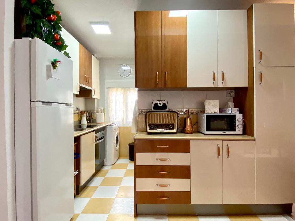 eine Küche mit weißen Schränken und einem Weihnachtsbaum in der Unterkunft Rosario house in Santa Pola