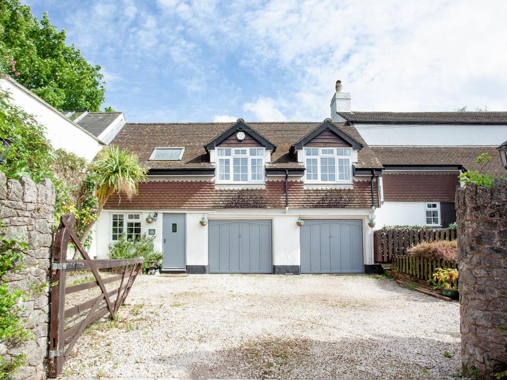 a house with two garage doors and a fence at Old Seaway Mews in Stokeinteignhead