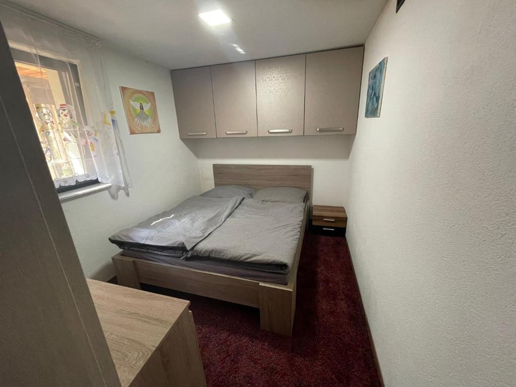 um pequeno quarto com uma cama e armários em Chata Miško em Snina
