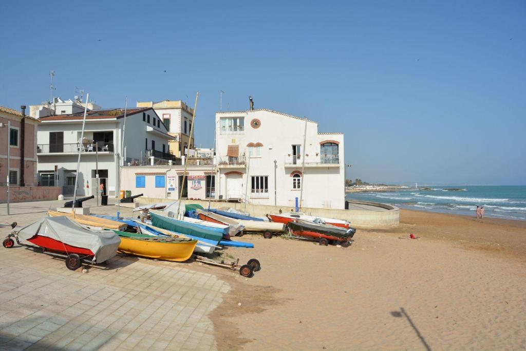 un grupo de barcos sentados en una playa en Fly Home Sicily, en Marina di Ragusa