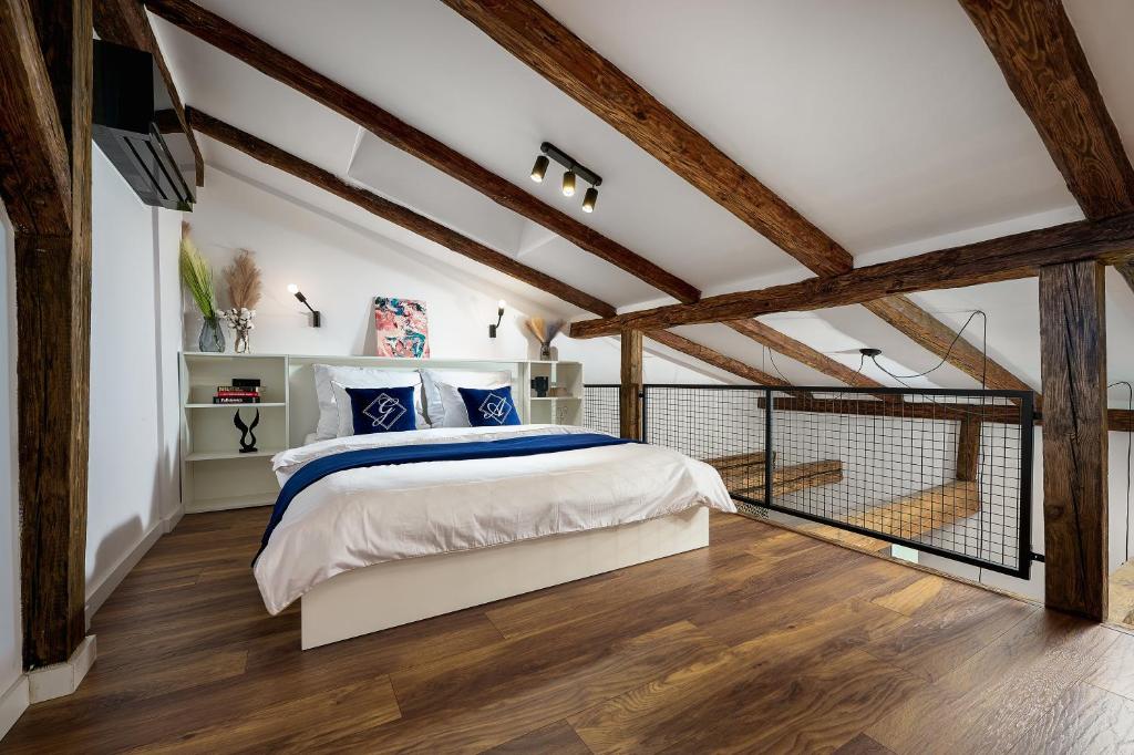 sypialnia z dużym łóżkiem i drewnianymi belkami stropowymi w obiekcie Apartamenty Piotrkowska 37 Loft w Centrum Łodzi Klimatyzacja w Łodzi