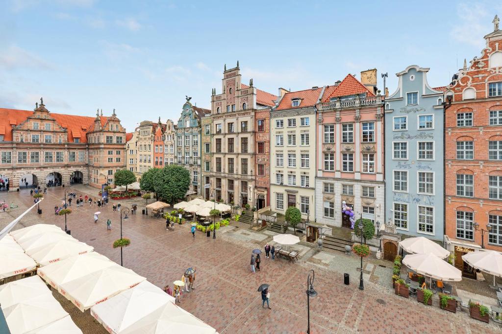una plaza de la ciudad con edificios y gente caminando por ahí en Comfort Apartments Długi Targ, en Gdansk