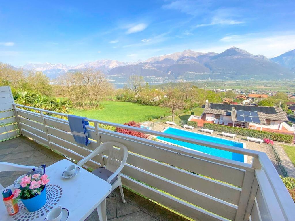 uma varanda com mesa, cadeiras e montanhas em Bellavista II Panorama Ferienwohnung mit Pool OG DG em Colico