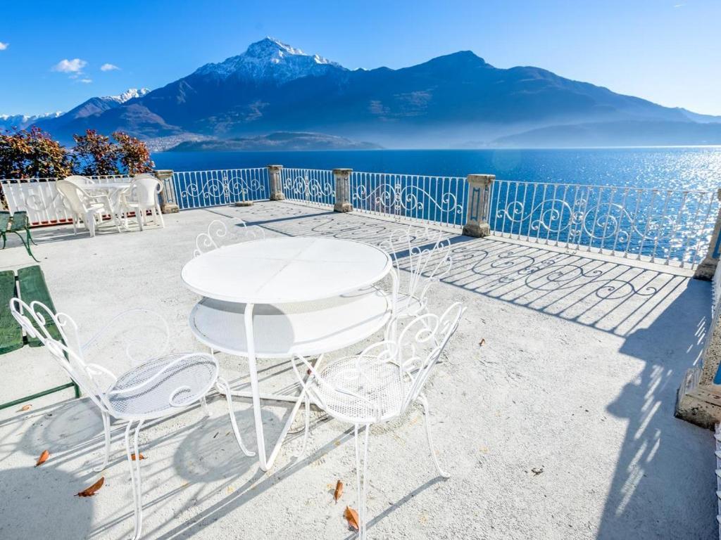 a table and chairs on a patio overlooking the water at Vento Tivano Garten Ferienwohnung in Domaso