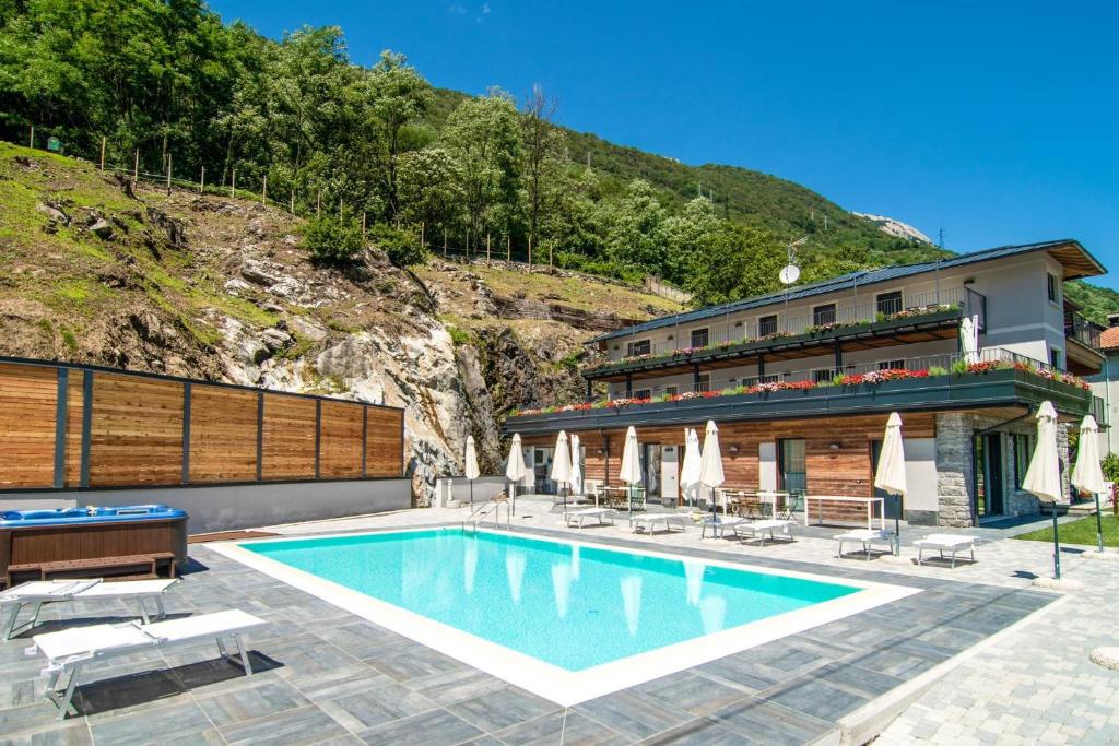 ein Hotel mit einem Pool vor einem Gebäude in der Unterkunft Dascio Oasi Ferienwohnung Dachterrassen am See in Dascio