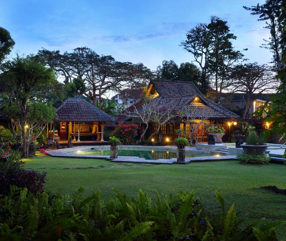 a large outdoor patio with a pool and trees at Alindra Villa in Nusa Dua