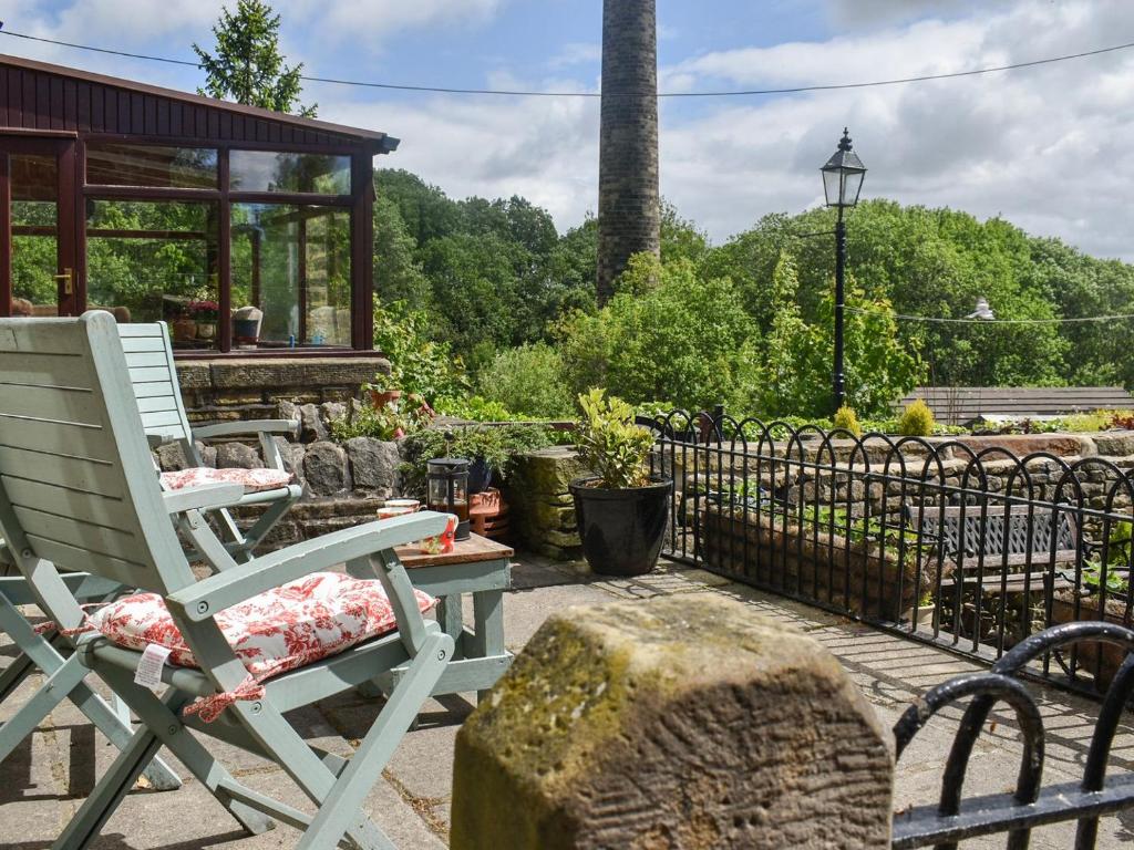 a rocking chair on a patio with a gazebo at Lodge Farm Cottage in Haworth