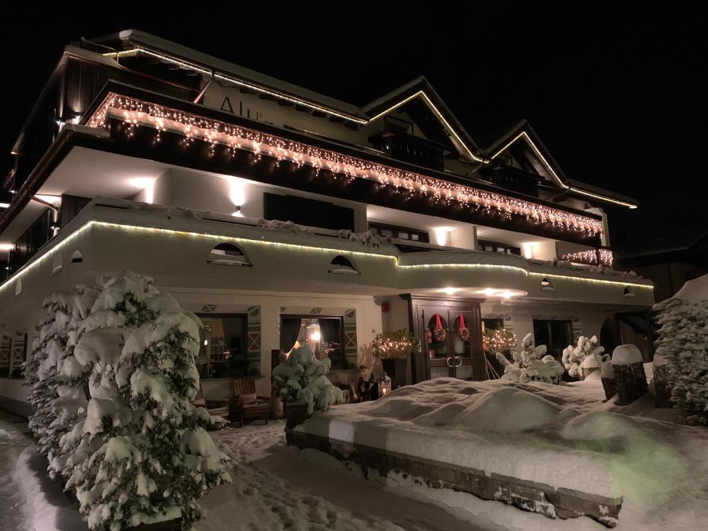 a building covered in snow at night at Hotel Alù Mountain Design in Bormio