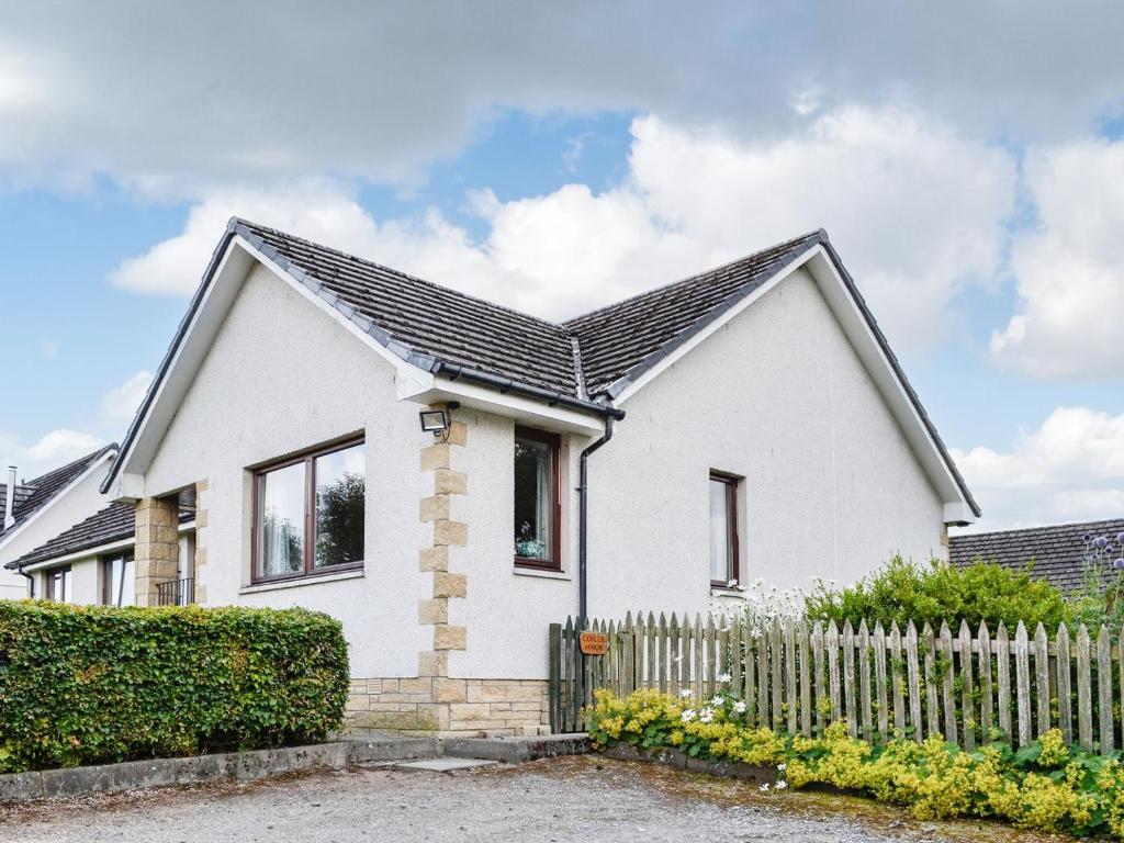 a white house with a fence in front of it at Coille Mhor in Clunie