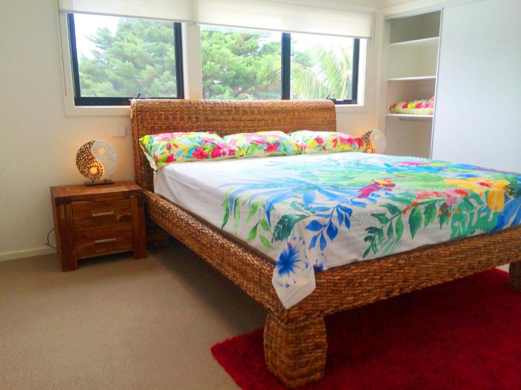 a bedroom with a bed with a colorful comforter at Award Winning Beach Front Retreat in Frankston