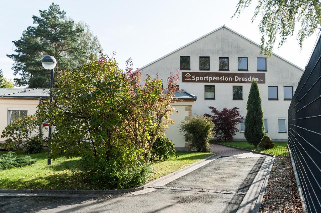 a white building with a street sign in front of it at Sportpension Dresden in Dresden