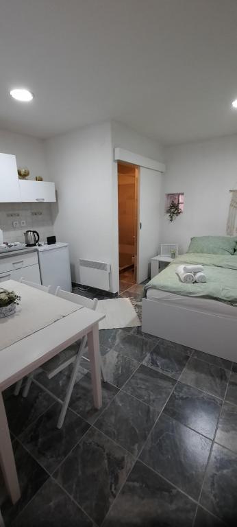 a room with a bed and a table and a kitchen at Studio apartman Centar in Varaždin