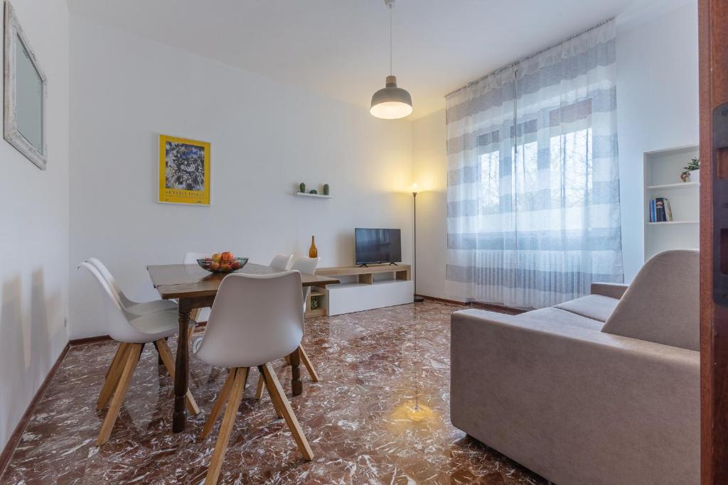 a living room with a couch and a table and chairs at Ferrara Charming apt 4 min walk from the bus stop! in Ferrara