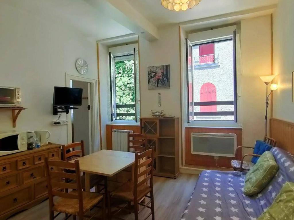 a living room with a table and a dining room at Appartement Cauterets, 3 pièces, 4 personnes - FR-1-234-139 in Cauterets