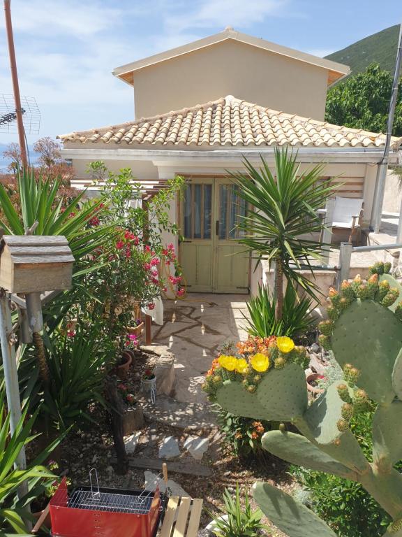 a house with a garden with flowers and plants at Villa Rena Agios Petros in Áyios Pétros