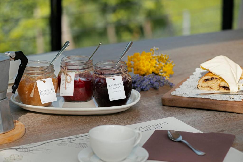 a table with jars of jam and a cup of coffee at Agriturismo Vigneto Vecio in Valdobbiadene