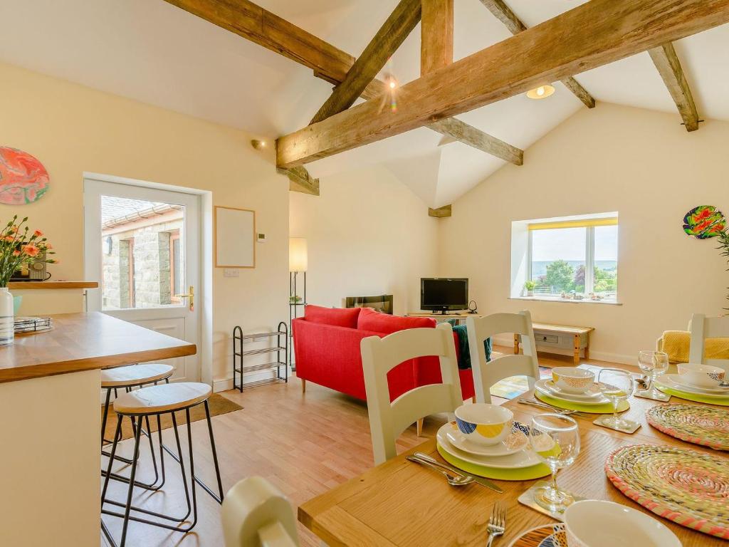 a living room with a table and a red couch at Courtyard Cottage - Uk39179 in Rossendale