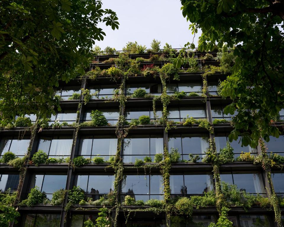 un bâtiment de bureau avec des plantes sur la façade dans l'établissement VILLA M, à Paris