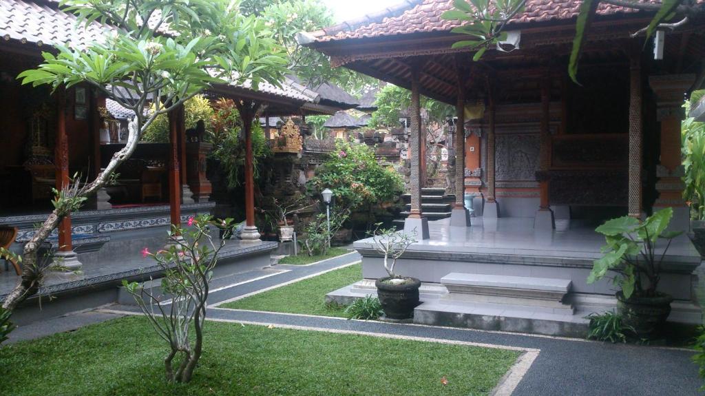 einen Innenhof eines Gebäudes mit Bäumen und Pflanzen in der Unterkunft Sukma Guest House in Ubud