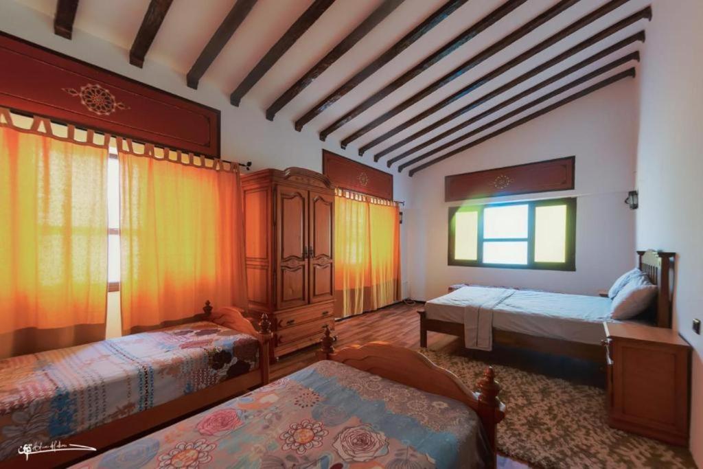 duży pokój z 2 łóżkami i oknem w obiekcie Casa Plasa Grande CHAOUEN w mieście Szafszawan