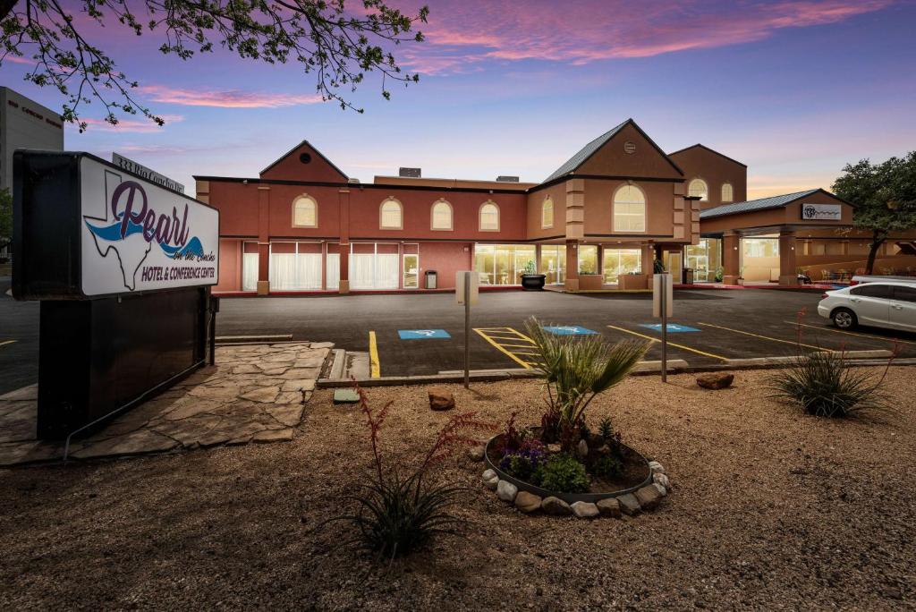 a building with a sign in front of a parking lot at Pearl on the Concho SureStay Collection by Best Western in San Angelo