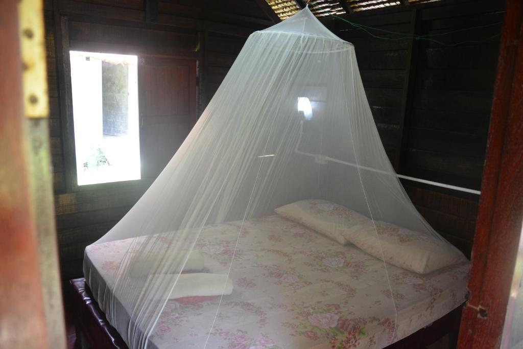 クラダン島にあるParadise Lost Bungalowsのネット付きの部屋のベッド1台
