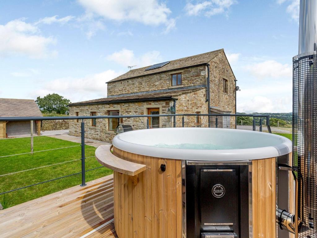 a hot tub on the deck of a house at Boococks Barn in Tosside