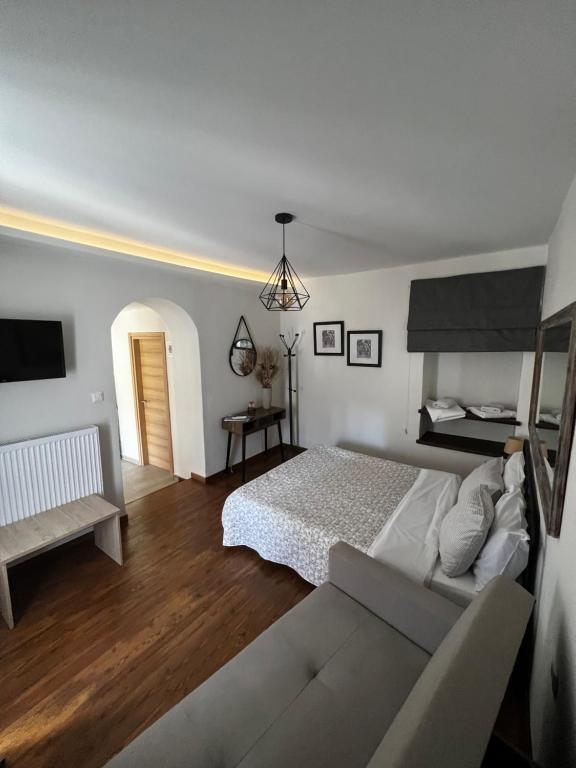 Alkistis House في فولوس: غرفة نوم بيضاء مع سرير وأريكة