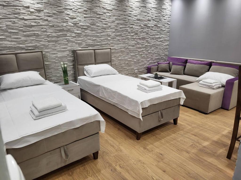 ヴルシャツにあるČavić apartmaniのベッド2台とソファが備わる客室です。