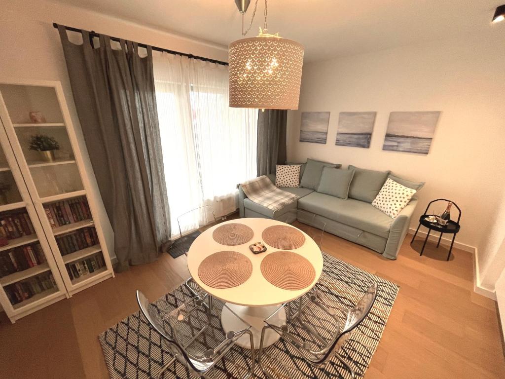 sala de estar con mesa y sofá en Jauna Teika Cosy 1bdr apartment, self check-in, en Riga