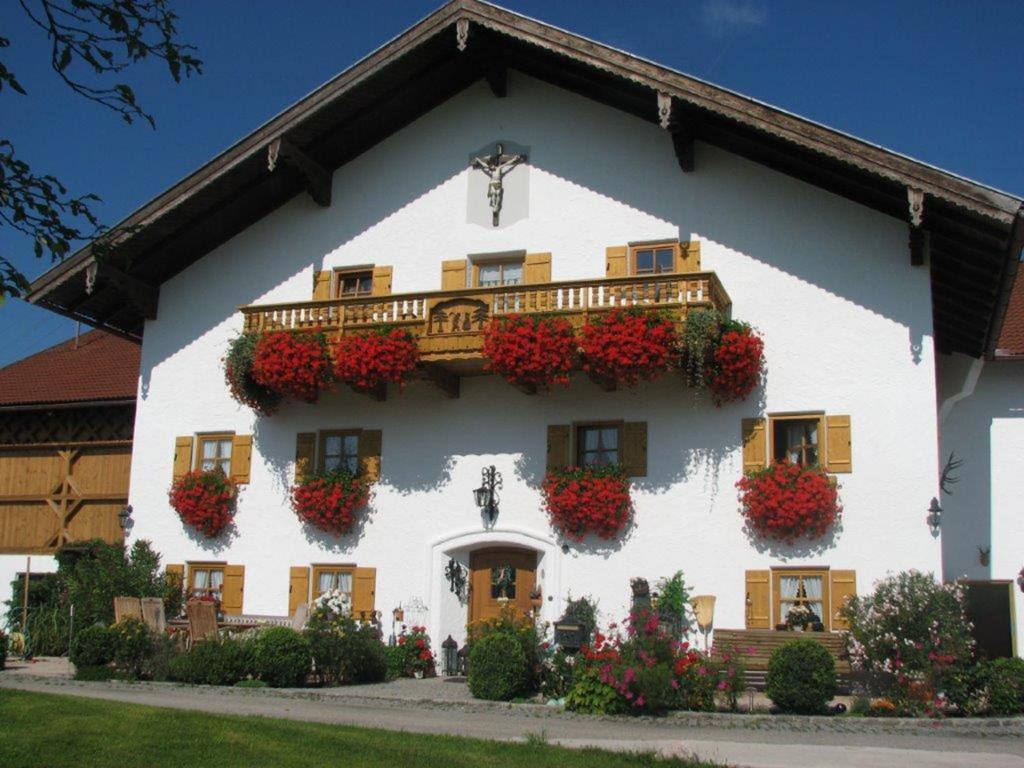 a white house with flowers on the side of it at Plattenberger Hof in Waging am See