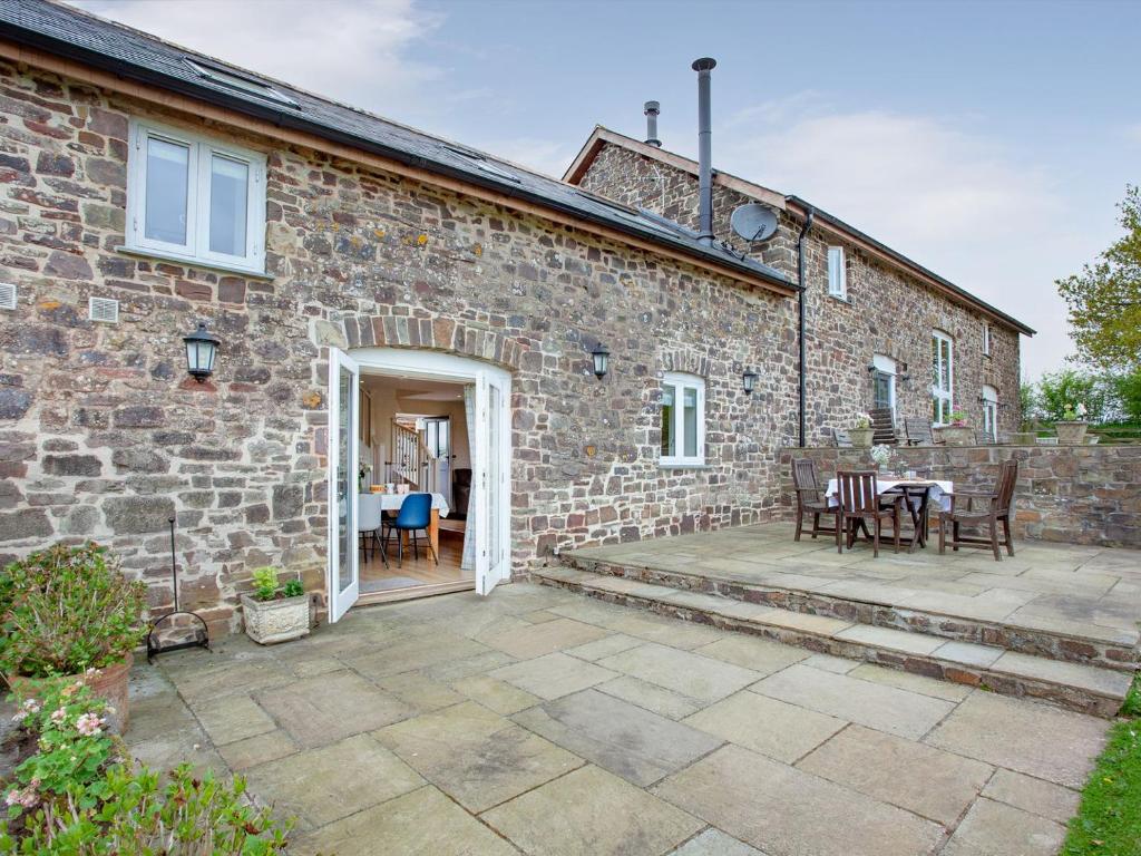 a brick house with a patio in front of it at Upper Red Down - Uk37699 in Witheridge